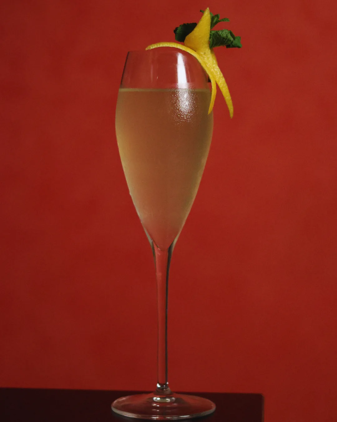 Sparkling cocktail in a champagne flute with lemon peel and mint, Obscura Tirana